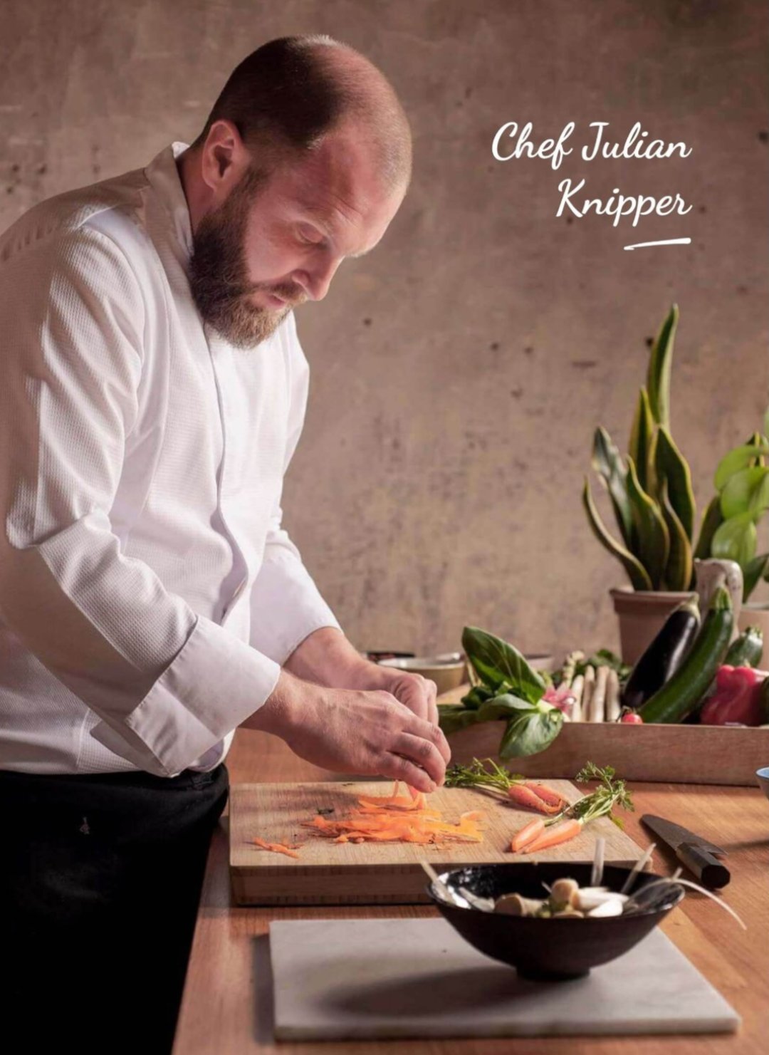 Chef Julian Knipper en train de découper des légumes sur une planche de bois